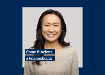 mulher usando camiseta cinza sorrindo e ao seu lado a escrita "como funciona a telemedicina" em uma caixa azul