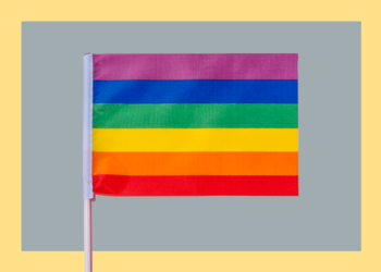 bandeira colorida em frente a fundo cinza e amarelo