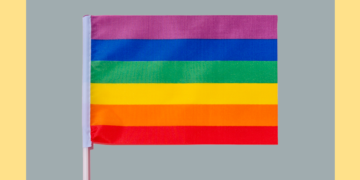 bandeira colorida em frente a fundo cinza e amarelo