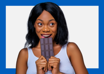 Mulher negra ameaça morder uma barra de chocolates sobre um fundo branco e azul.