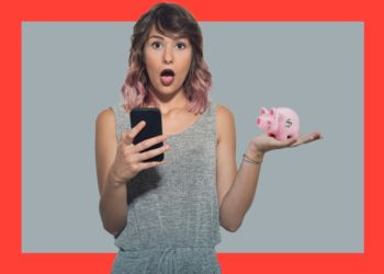 Mulher de cabelos rosas e blusa cinza segura o celular numa mão e um cofrinho em formato de porquinho na outra, fazendo cara de espanto. O fundo é cinza e coral.