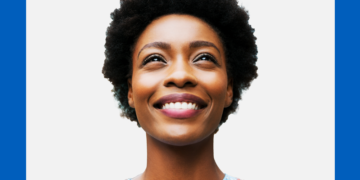 Mulher olha para o alto sorrindo sobre fundo branco e azul